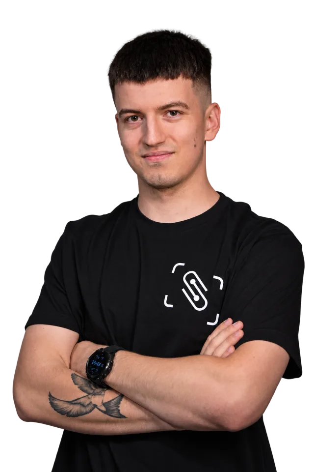 Tomek z Sybernetic w firmowej koszulce, ze skrzyżowanymi rękami